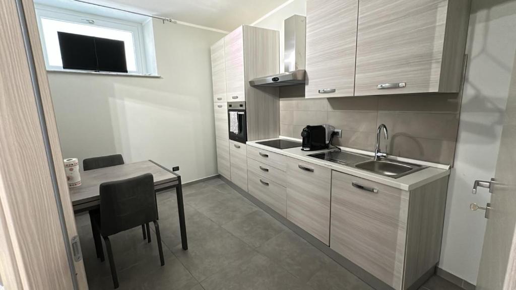 a small kitchen with a table and a sink at Residence Parco Castello 1 in Novi Ligure