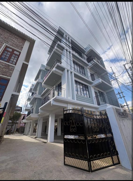 a white building with a gate in front of it at The Olive Inn in Shillong