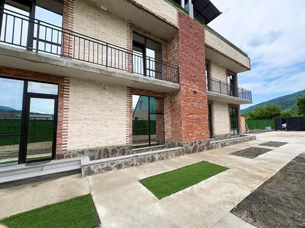 a brick building with grass in front of it at Pinevillasadgeri in Borjomi