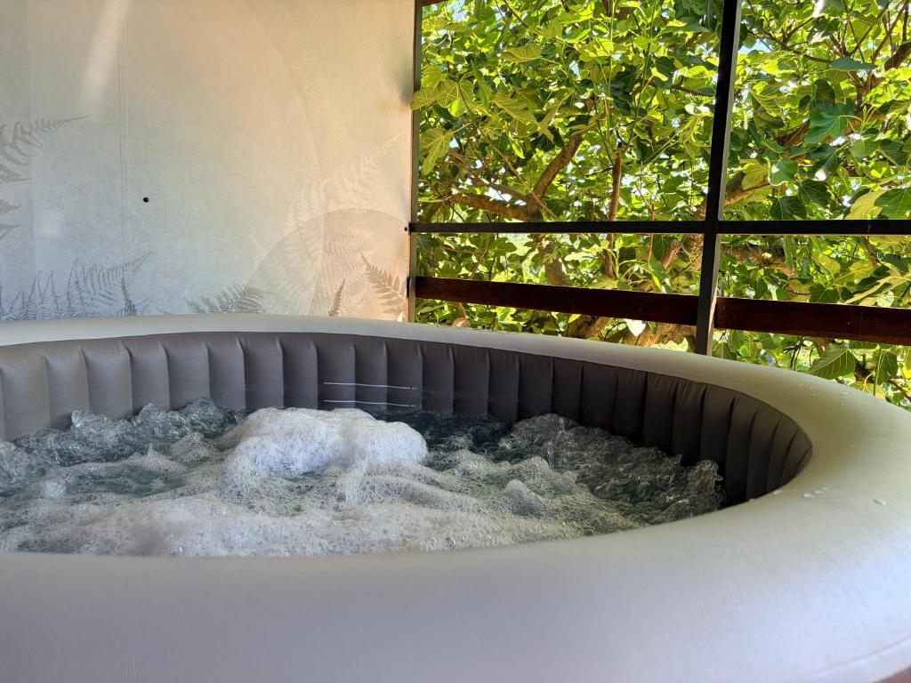 a bath tub in front of a window at Chalet Le Klet in Krapinske Toplice