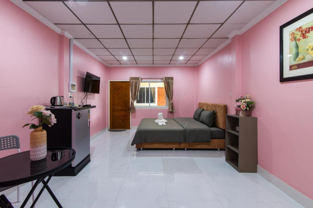 a pink bedroom with a bed and a desk at PoonsukPlace Sampran in Ban Bang Yai Chuai