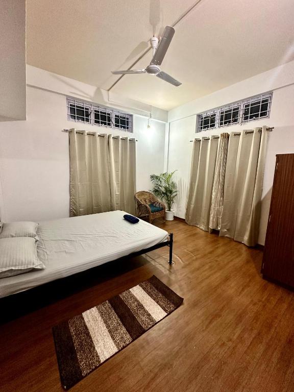 a bedroom with a bed and a ceiling fan at The Gulmohar Grove in Pāsighāt