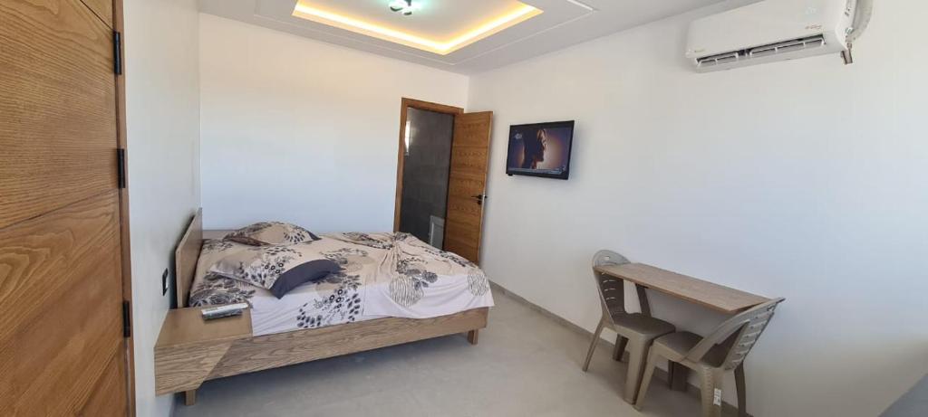 a small bedroom with a bed and a desk at Dar Lebharr Studio in Kelibia