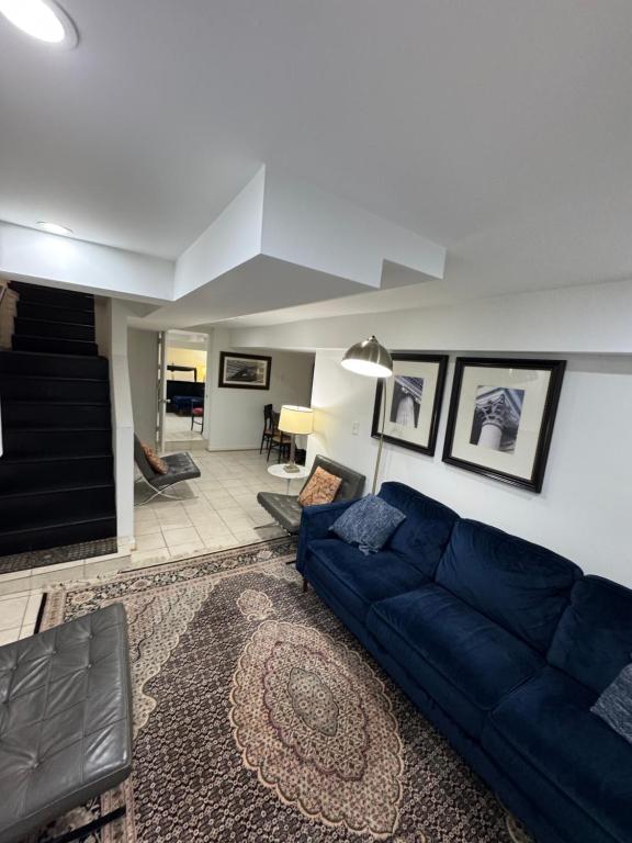 a living room with a blue couch in a room at COMFY Basement Home 2 Bdrm1Den 3Queen Beds in Washington, D.C.