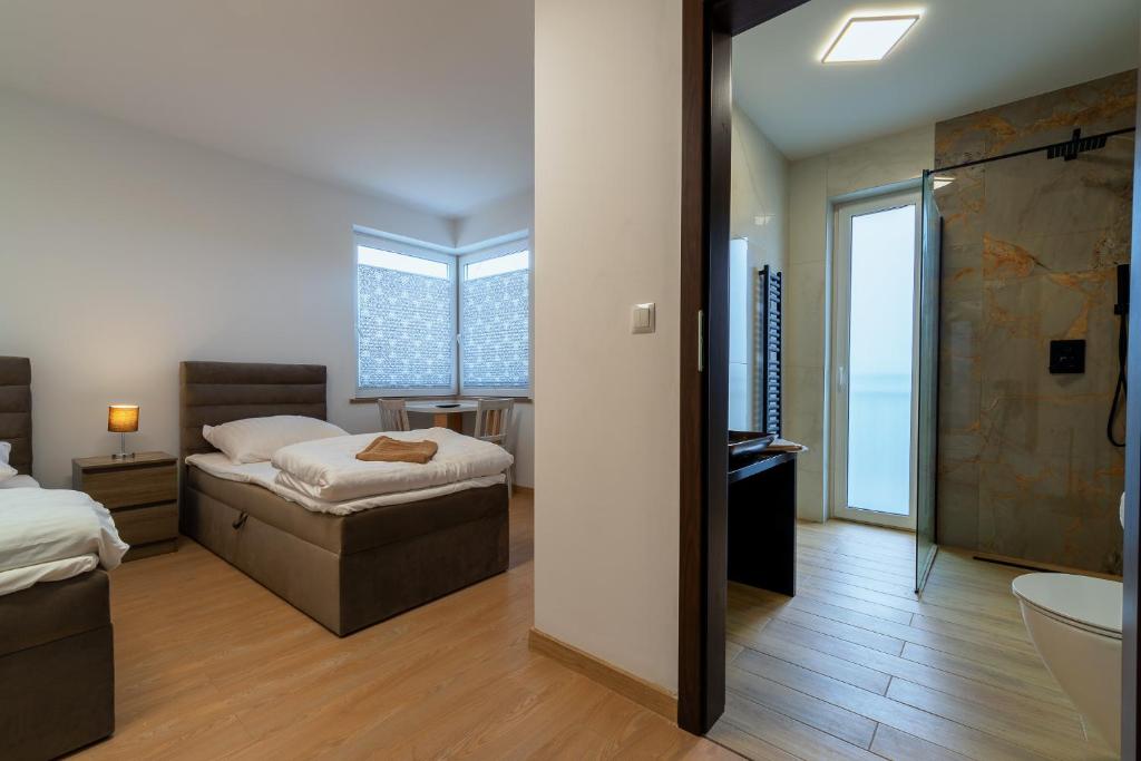 a bedroom with two beds and a bathroom with a tub at Lipove Spa in Lipowe