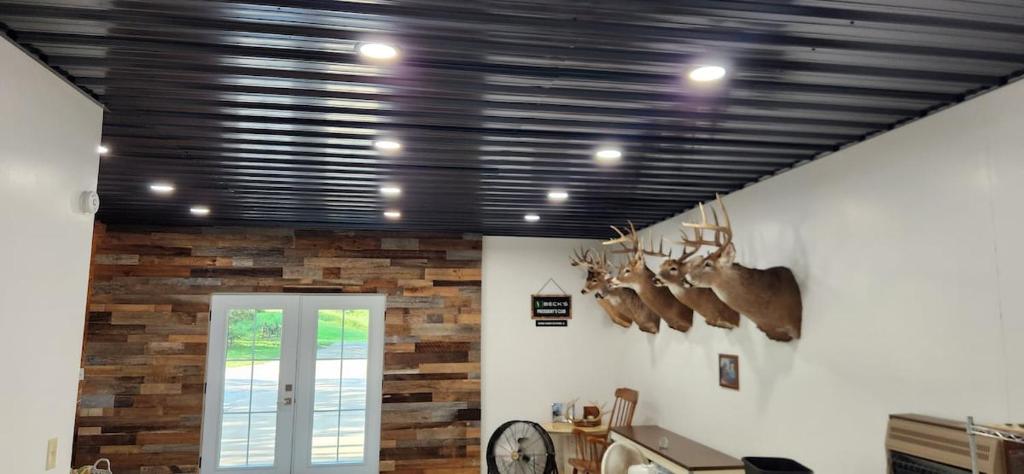 a living room with a ceiling with black beams at The Cabin at Solitude Junction in Opdyke