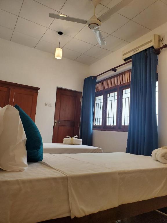 two beds in a room with blue curtains at 2 Bed Apartment in Colombo 3 in Colombo