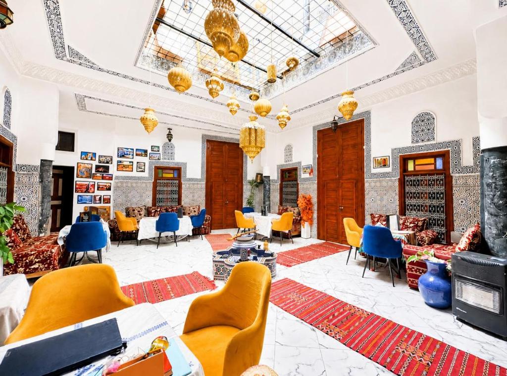 a lobby with yellow chairs and tables at Riad Dar El Kaid in Fez