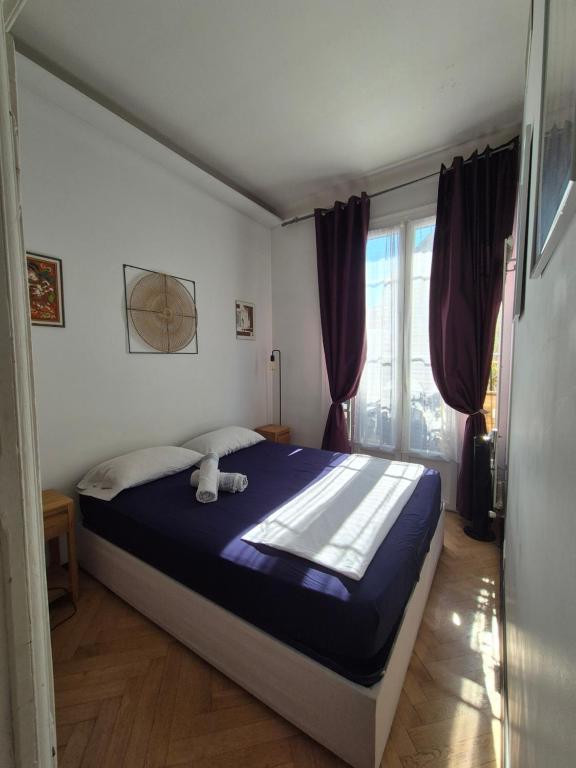 a bedroom with a large bed with a blue blanket at Wonderful heart of Nice in Nice