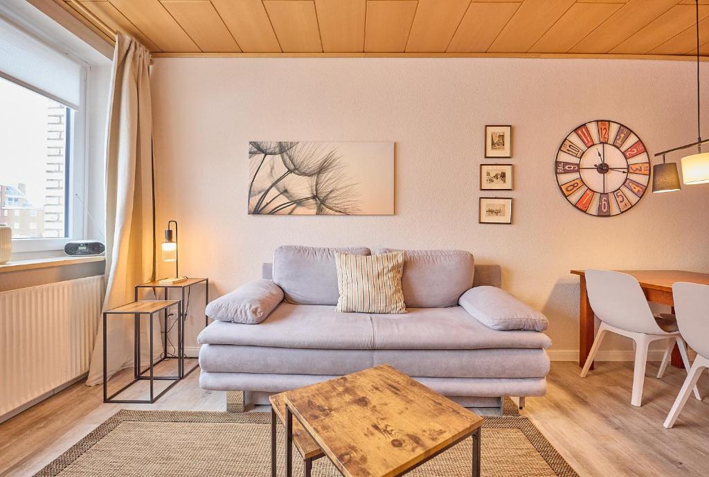 a living room with a couch and a table at Haus Schildt, FeWo 7 in Duhnen