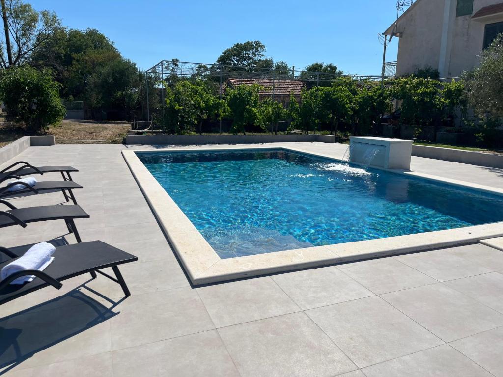 a swimming pool with two chairs and a table at Pax et Bonum in Lozovac