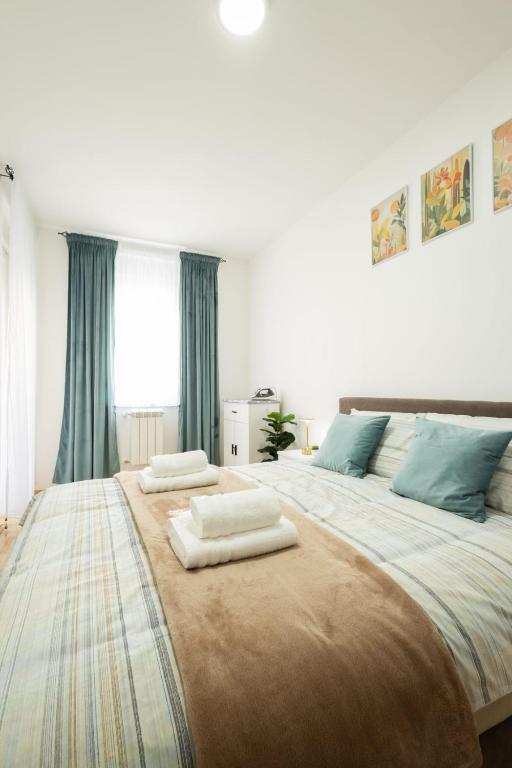 a large bed with two towels on top of it at Dana in Požarevac