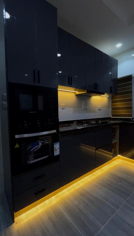 a kitchen with black cabinets and an oven at Heritage Apartment in Ibadan