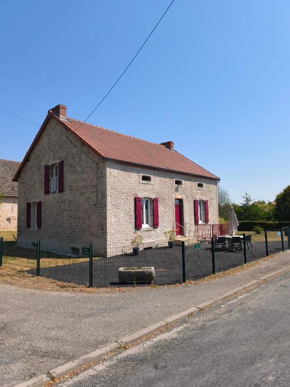 a brick house with red shutters on a street at Camp'Amis in Viersat