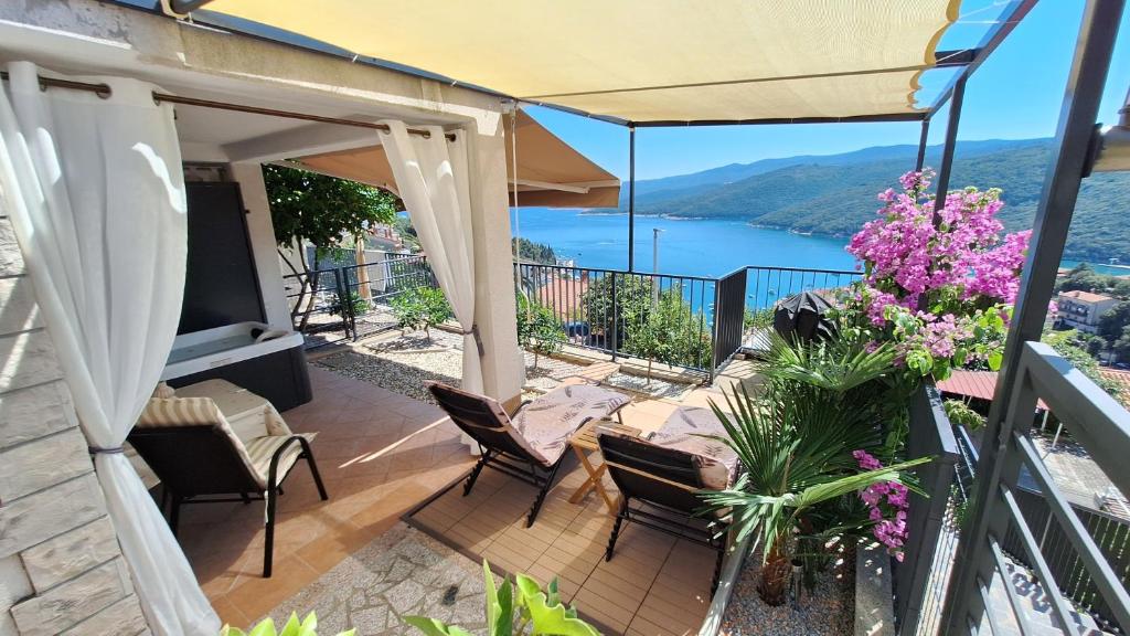a balcony with a view of a lake at Studio Apartment Đuli Rabac with private hot tub, bike box and free parking in Rabac