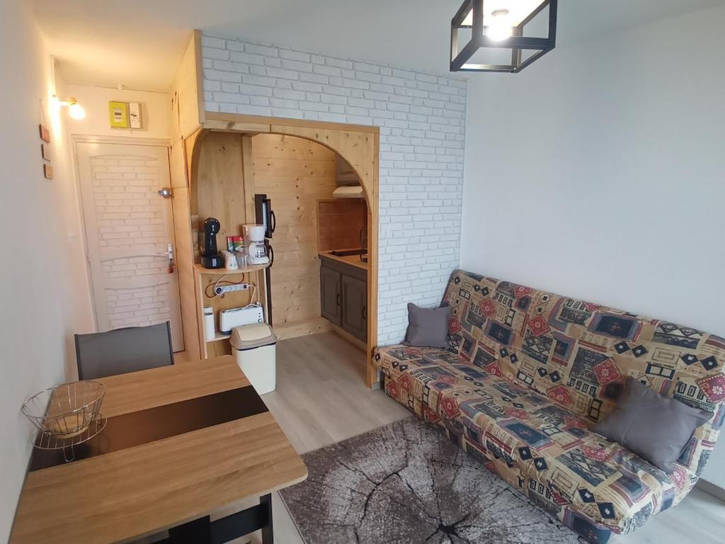 a living room with a couch and a table at Profitez de la vue in Ustou