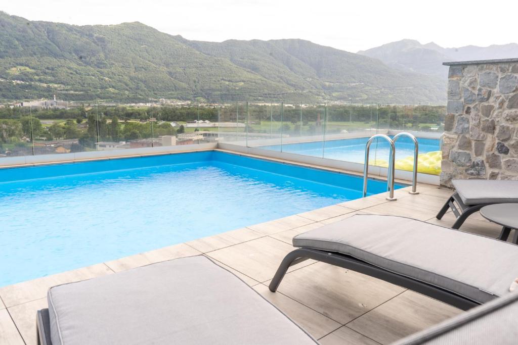 a swimming pool with a view of mountains at Villa Sementina - Luxury Stay with Pool and Gym - 15 m to Lake Maggiore in Bellinzona