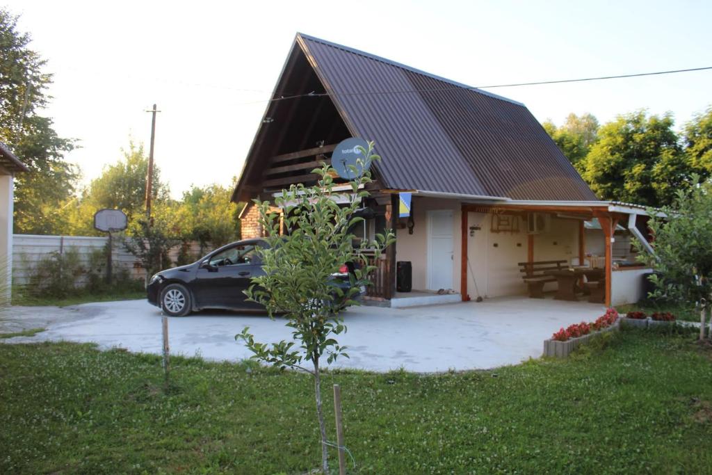 a car parked in front of a small house at Vikendica Peace in Brezje