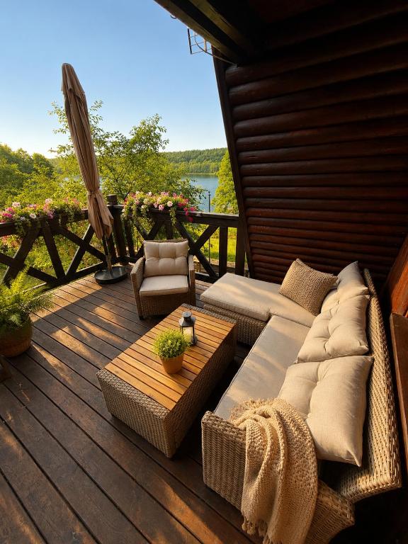 a porch with a couch and a table on a deck at Wiśniowa Chata in Rentyny