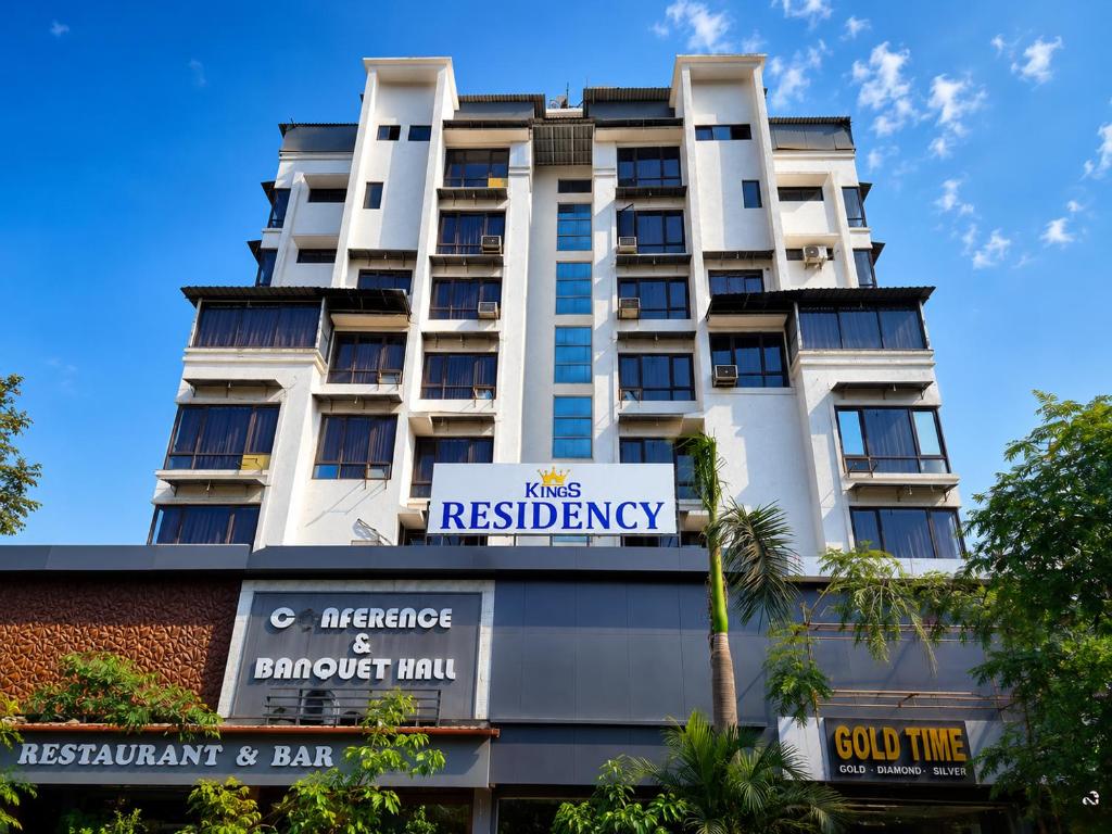 a tall white building with a sign in front of it at Hotel Kings Residency Panvel in Navi Mumbai