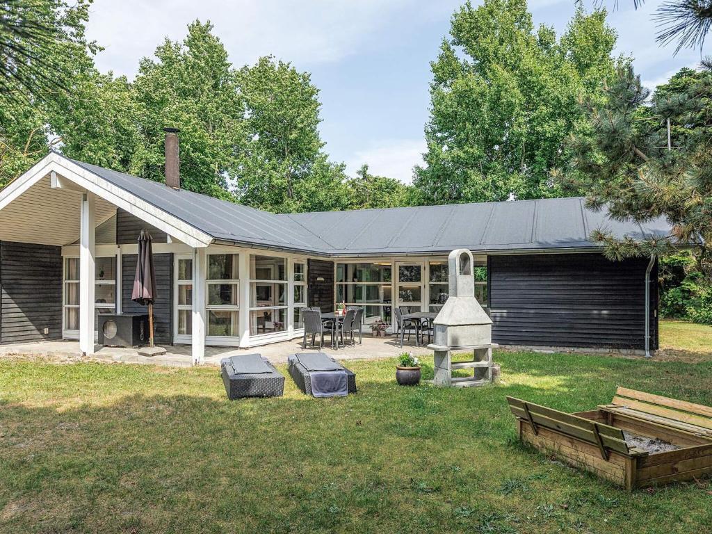 a house with a porch with two stools in the yard at 4 star holiday home in Væggerløse in Bøtø By