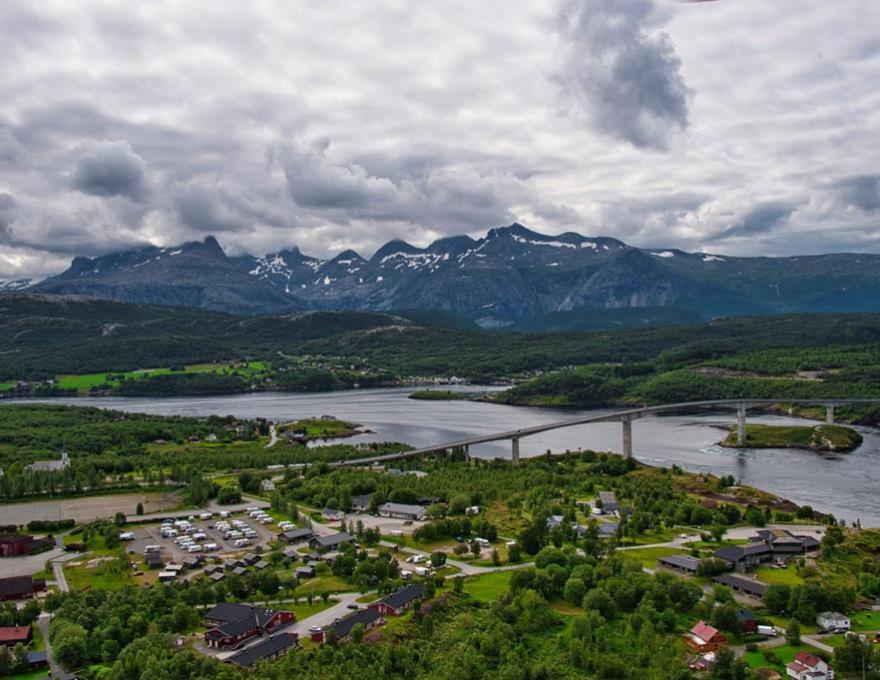 an aerial view of a town with a river and a bridge at Saltstraumen camping in Bodø