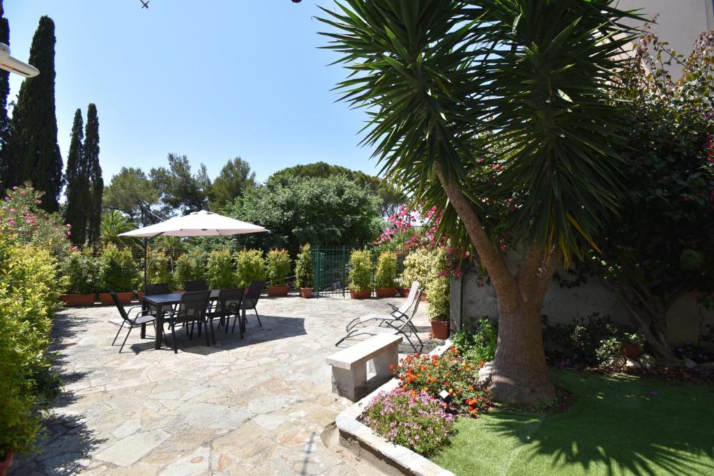 a patio with a table and chairs and a palm tree at Casa Lorica in Pieve Ligure
