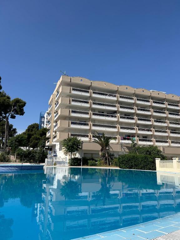 a hotel with a swimming pool in front of a building at Cozy Apartment with Pool at 5 Min to Beach in Salou