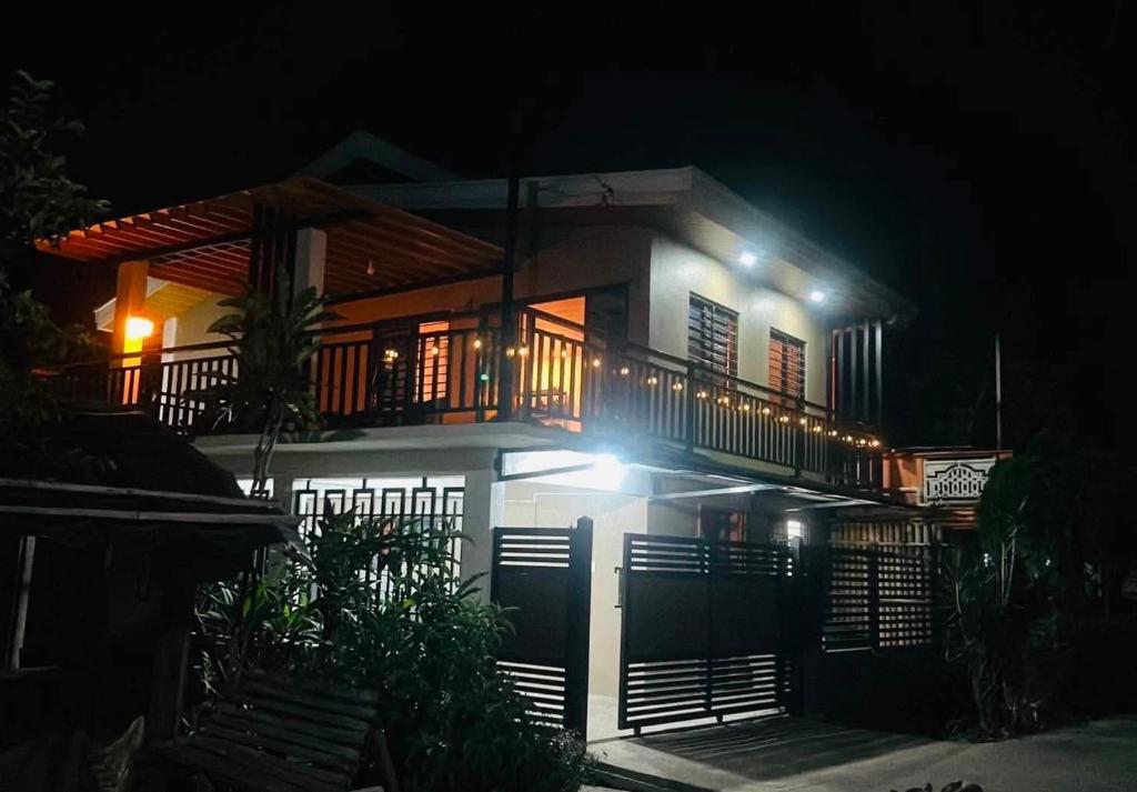 a white house with a balcony at night at Casa Domingo Guest House in Camalig