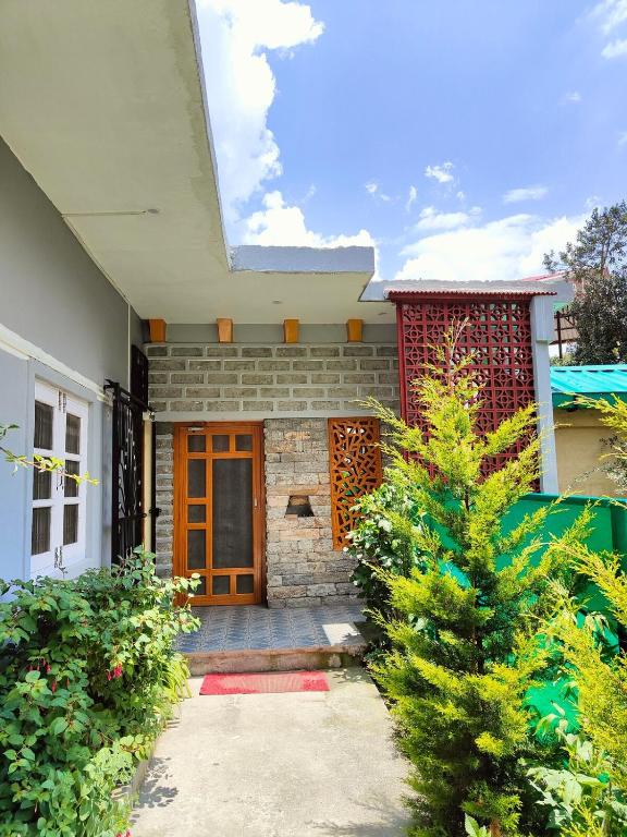 a house with a christmas tree in front of it at MP Residency Homestay in Munsyari
