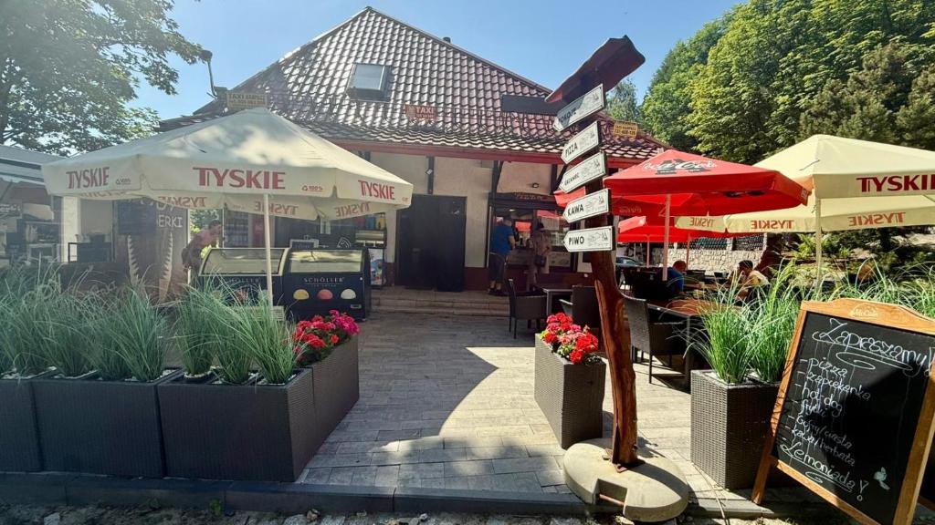 a restaurant with tables and umbrellas and plants at Dom przy Wangu Karpacz in Karpacz