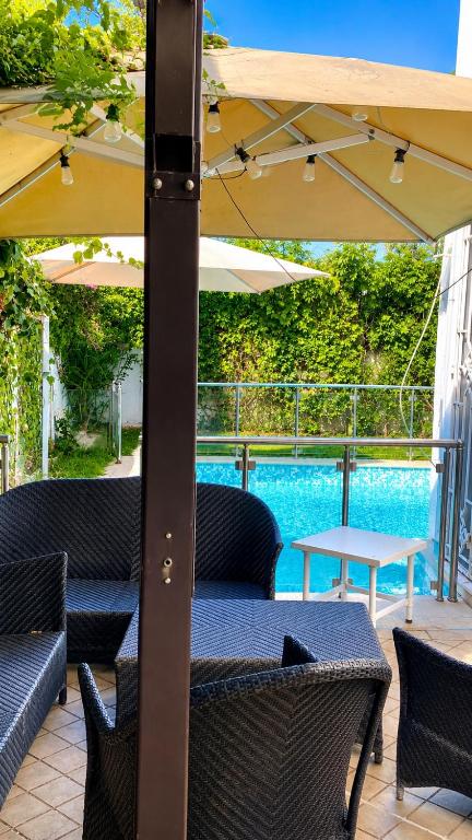 a table and chairs under an umbrella next to a pool at Villa Bleu Horizon in El Haouach