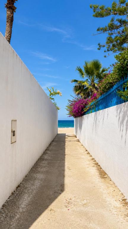 a path along a white wall next to the beach at Villa Sidi Abdelaziz in Tunis