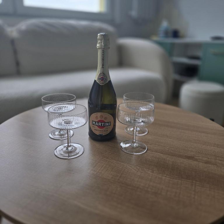a bottle of wine and two glasses on a table at Apartament "Agatka" in Hel