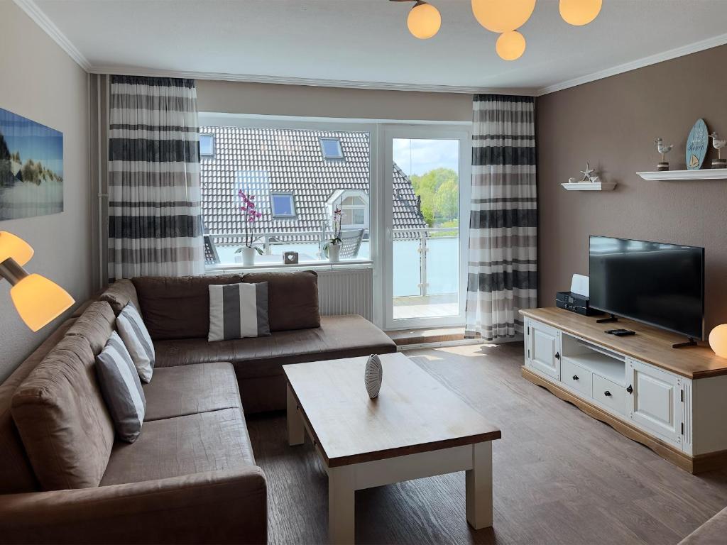 a living room with a couch and a tv at Ferienwohnung *Jessen´s Wattblick* in Wittdün