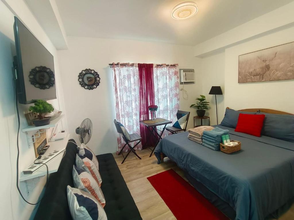 a bedroom with a bed and a table with chairs at Hailey's Place Unit 2 in Bacolod