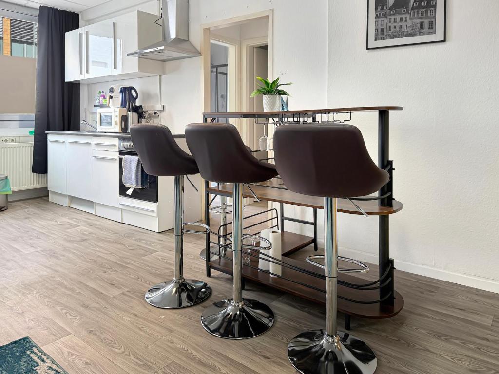 a kitchen with a table and three bar stools at Gruppenloft Stuttgart Kicker & 14 Gäste in Stuttgart