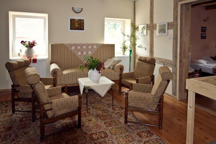 uma sala de estar com cadeiras e uma mesa com um vaso em Winnica Agat em Świerzawa