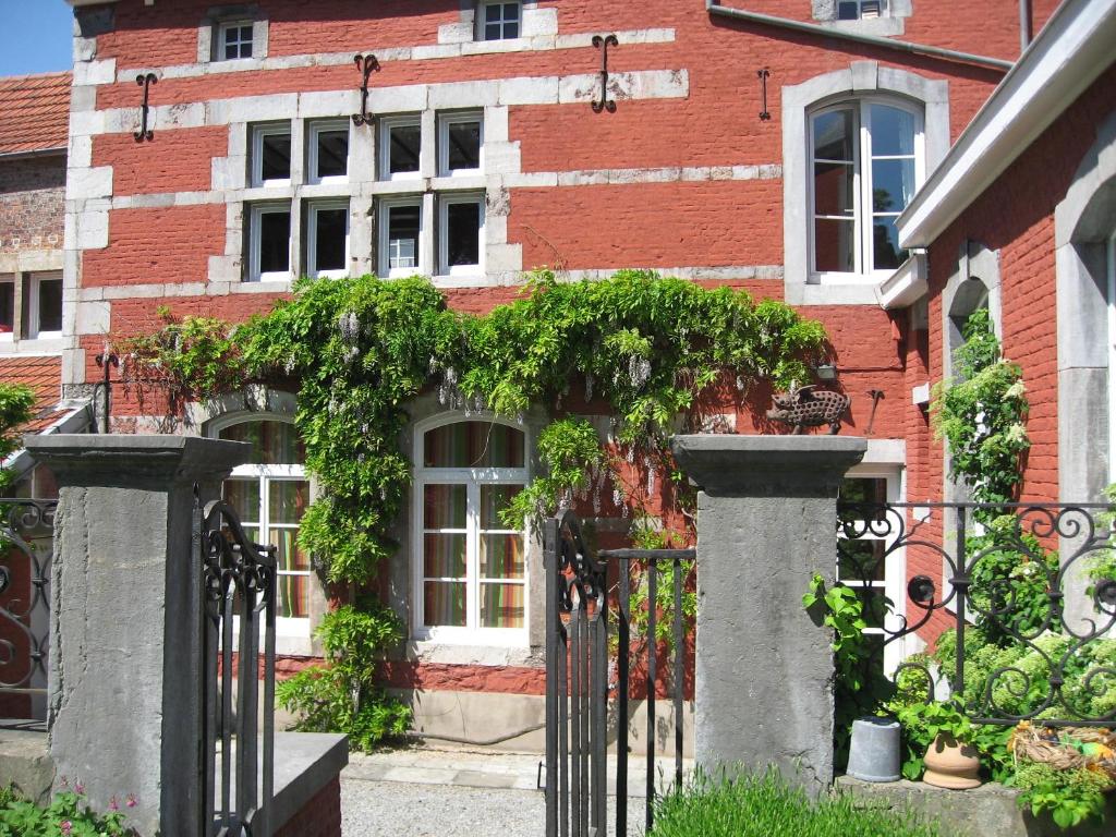 um edifício de tijolos com um portão em frente em Chambre d'Hôtes Les Augustins - Parking sécurisé - Borne de recharge em Huy