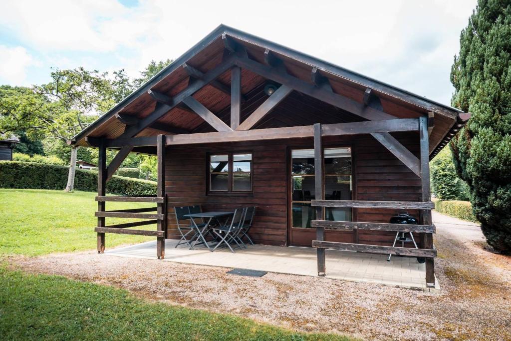 a small cabin with a table in the grass at Domaine de Guillaume Chalet 4 Pers in Auquainville