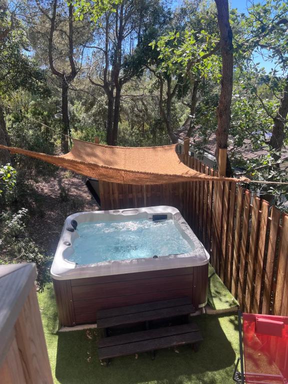 a hot tub in a hammock in a yard at Chalet Cannelle Spa camping Buffalo Hacienda in La Seyne-sur-Mer