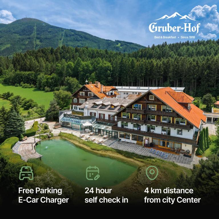 an aerial view of a hotel with a lake at Hotel Gruberhof Innsbruck Igls B&B in Innsbruck