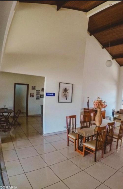 a dining room with a table and chairs in a room at Pousada Pedra Branca in Corinto
