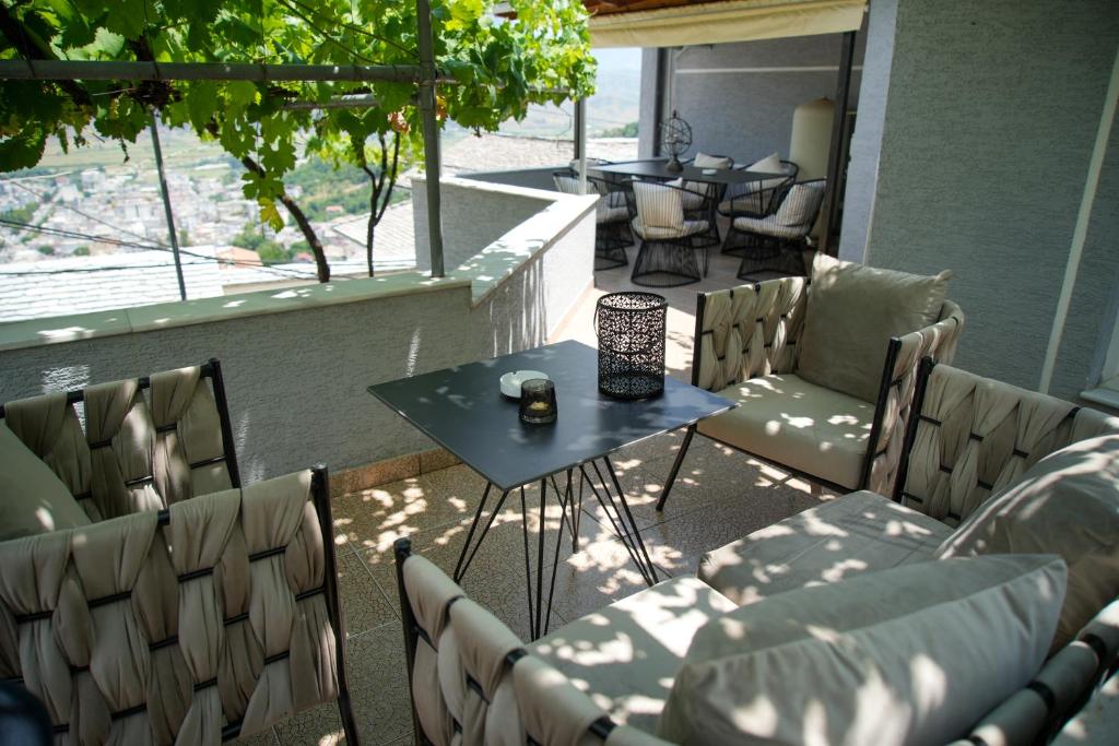 a patio with a table and chairs on a balcony at Old Bazaar Balcony Villa in Gjirokastër