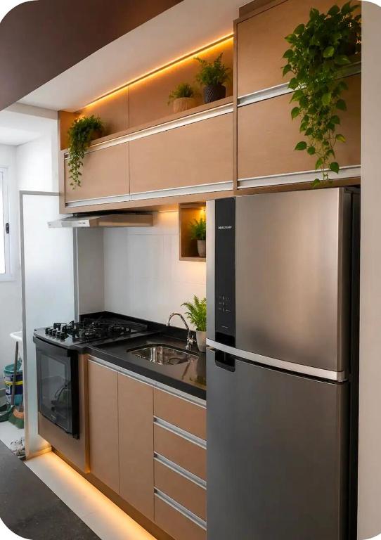 a kitchen with a stainless steel refrigerator and a stove at Comfortable Apartment Near Alphaville in Jandira