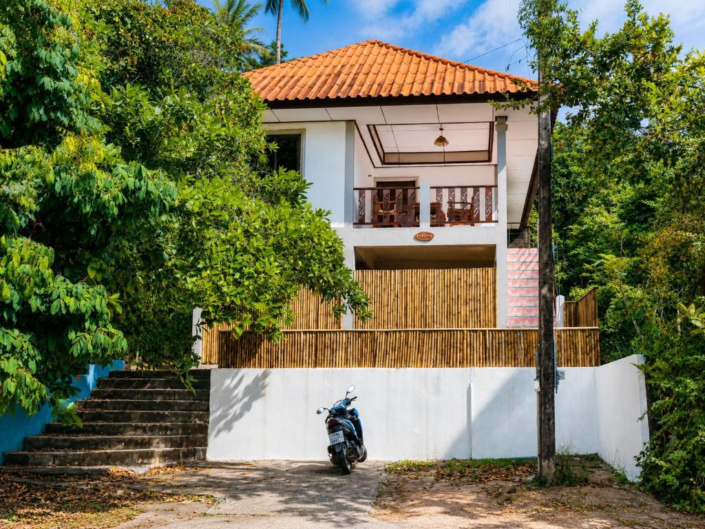 a motorcycle parked in front of a house at Amsterdam House - Hin Kong - Double King Bed - 4K SmartTV in Wok Tum