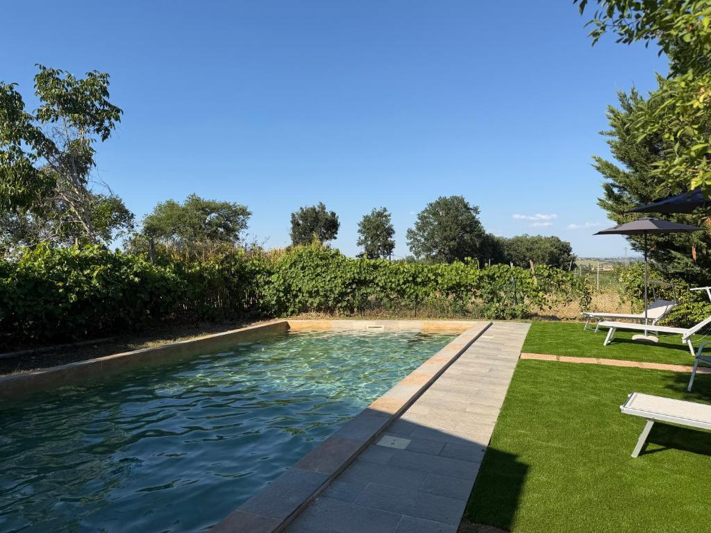 a swimming pool in a yard with a bench at Podere Tre Berte - The Sleeping Beauty in Acquaviva