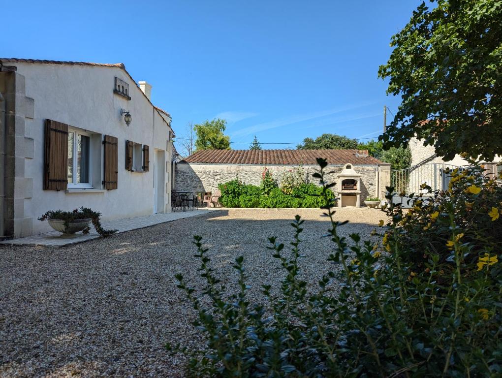 a house with a gravel driveway next to a building at Bellevue in Châteaubernard