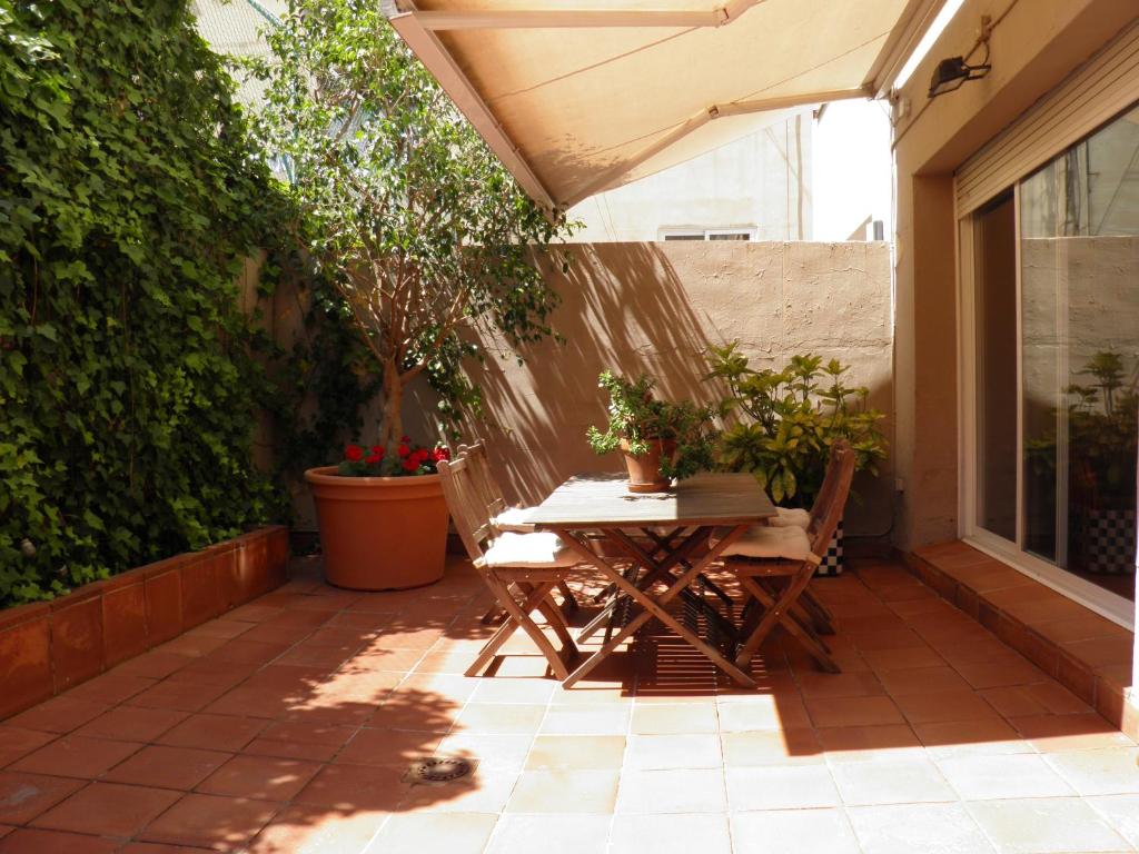 um pátio com uma mesa, cadeiras e plantas em Suitur Courtyard Apartment em Barcelona