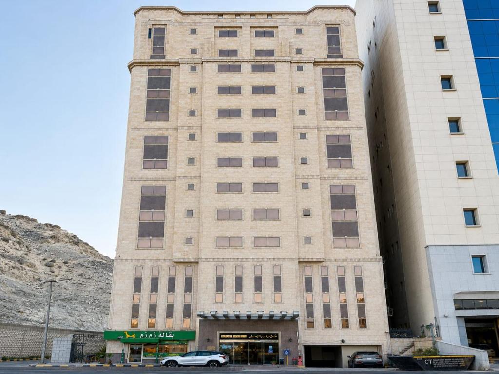 a tall building with a car parked in front of it at فندق مواسم الاحسان توصيل مجانى للحرم in Al ‘Azīzīyah